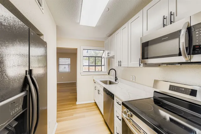 a kitchen with a sink stove and microwave