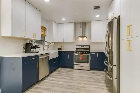 a kitchen with kitchen island granite countertop a stove top oven a sink and a refrigerator