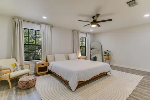 a bedroom with a large bed chandelier and a window