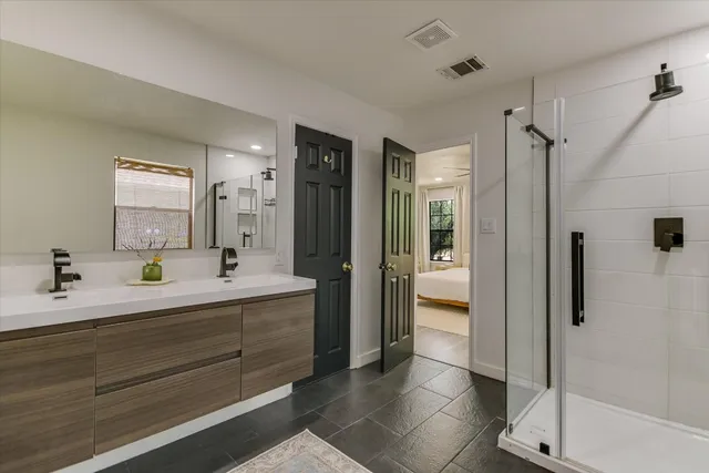 a en suite bathroom with a double vanity sink a mirror and a shower