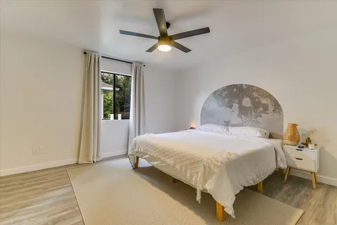 a bedroom with a bed and a ceiling fan