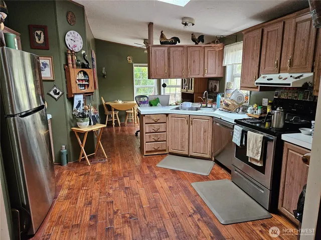 a kitchen with stainless steel appliances granite countertop a refrigerator a stove top oven a sink and dishwasher