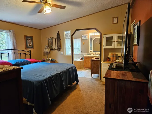 a bedroom with a large bed and dresser with mirror