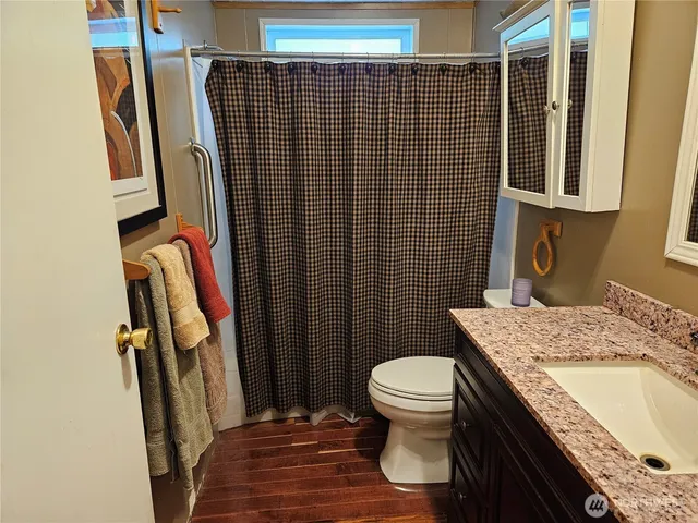 a bathroom with a granite countertop sink toilet and shower