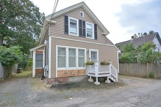 a wooden bench sitting in front of a house