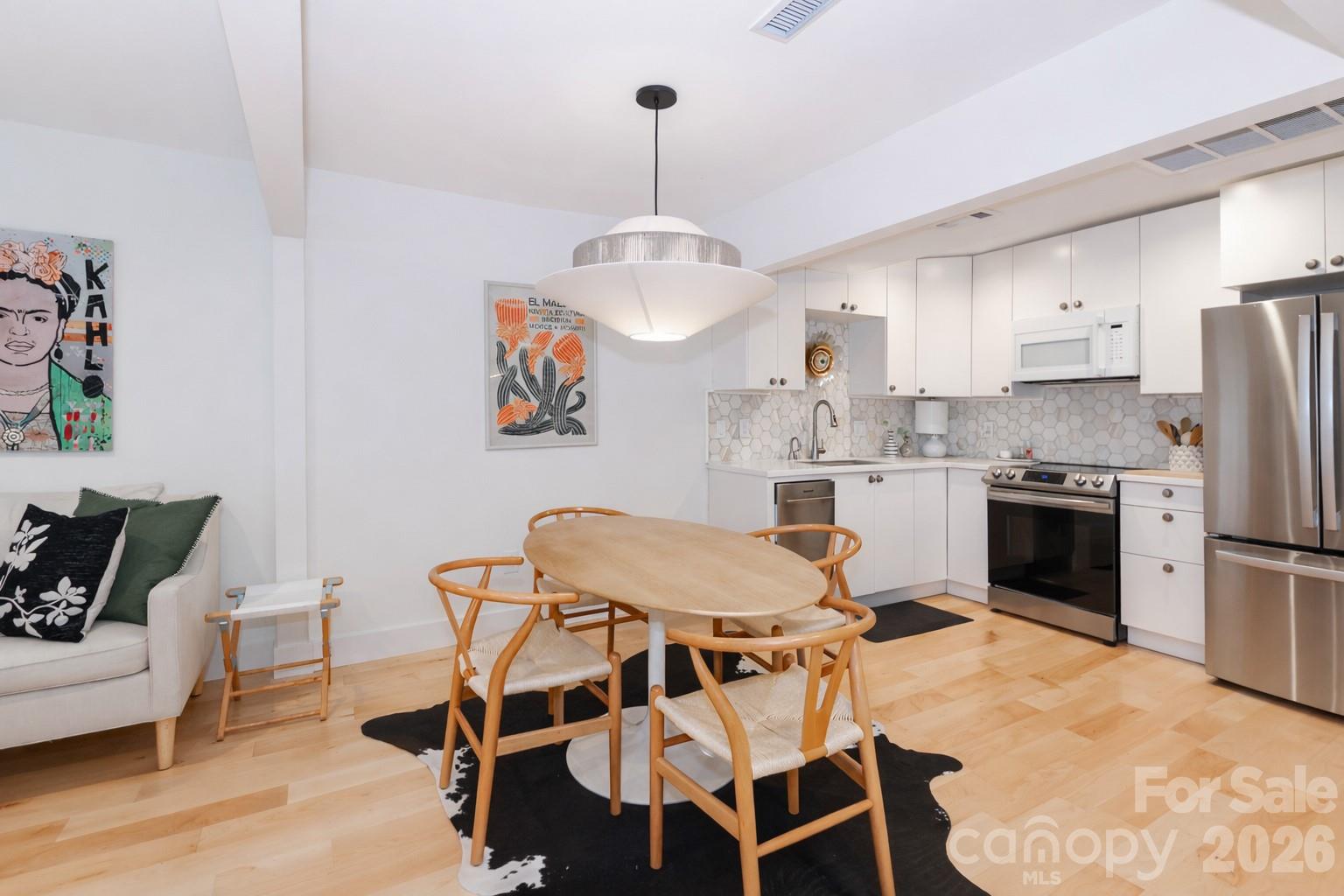6622 Thermal Road Charlotte, NC 28211 - Photo 12 of 36 a kitchen with stainless steel appliances kitchen island granite countertop a dining table chairs and a refrigerator