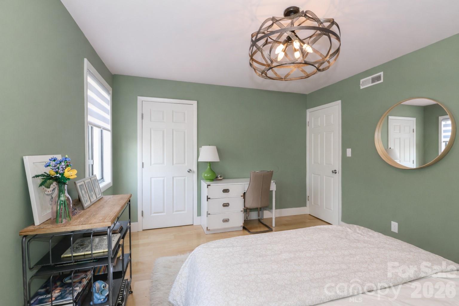 6622 Thermal Road Charlotte, NC 28211 - Photo 28 of 36 a bedroom with a bed a chandelier and a mirror