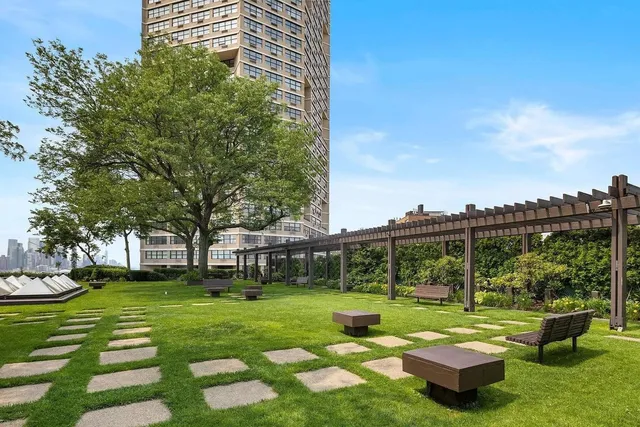 a view of a white house with a yard table and chairs