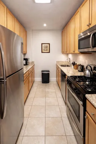a kitchen with stainless steel appliances granite countertop a refrigerator stove top oven a sink and dishwasher