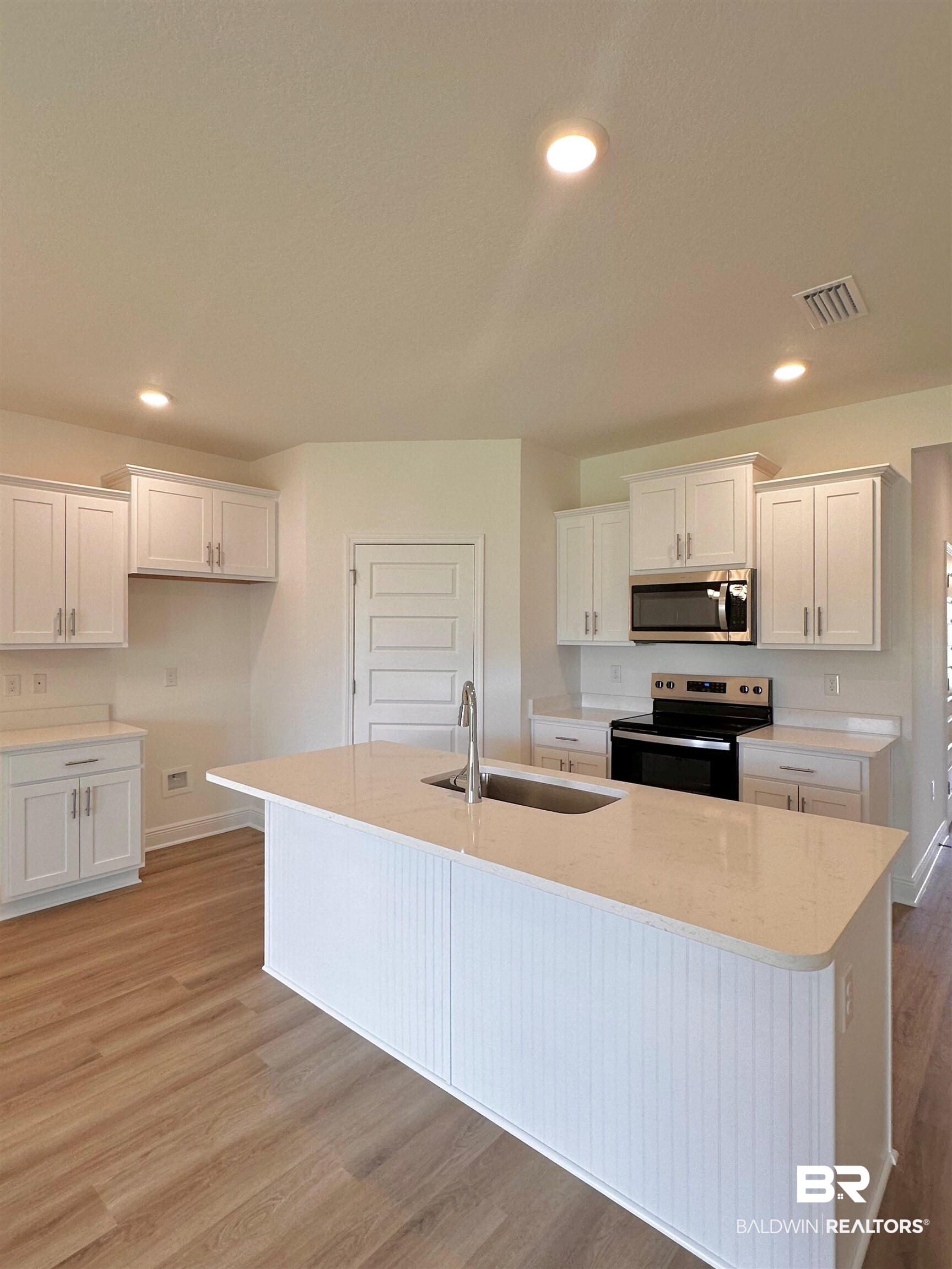 12946 Grand Rpds Road Fairhope, AL 36532 - Photo 3 of 19 Kitchen featuring light hardwood / wood-style floors, sink, white cabinets, and stainless steel appliances