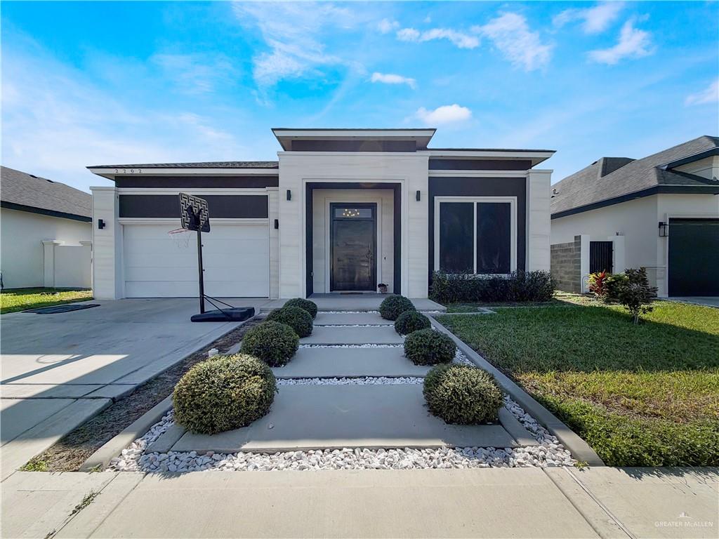 2202 Mirabelle Street Mission, TX 78572 - Photo 1 of 18 a front view of a house with a yard and potted plants