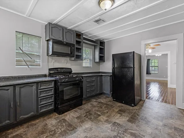 a kitchen with stainless steel appliances granite countertop a refrigerator stove and sink