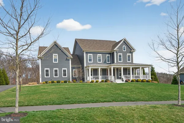 a front view of a house with a yard and trees
