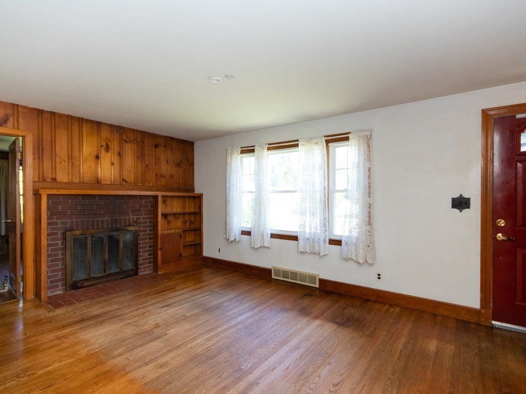 64 Judith Road Weymouth, MA 02191 - Photo 6 of 27 an empty room with fireplace wooden floor and windows