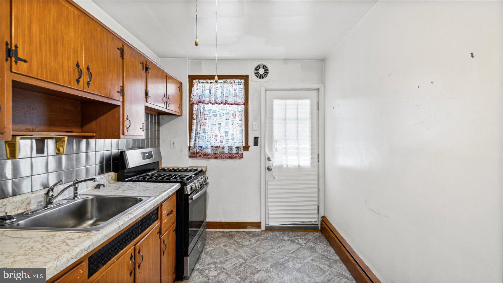 1805 Crestview Road Baltimore, MD 21239 - Photo 16 of 39 a kitchen that has a sink a stove and a window