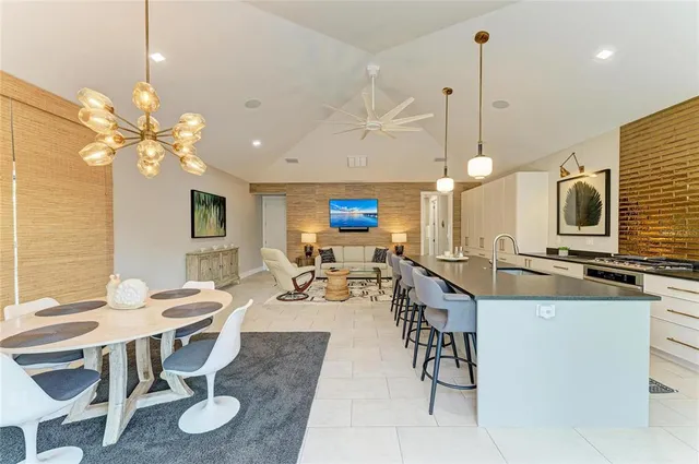 a large white kitchen with a large window and stainless steel appliances