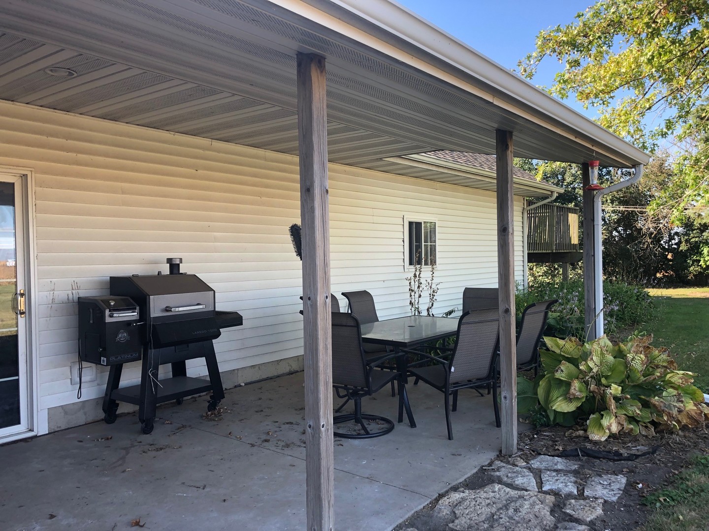 791 North 36th Road Utica, IL 61373 - Photo 4 of 24 a backyard of a house with dining table and chairs with plants
