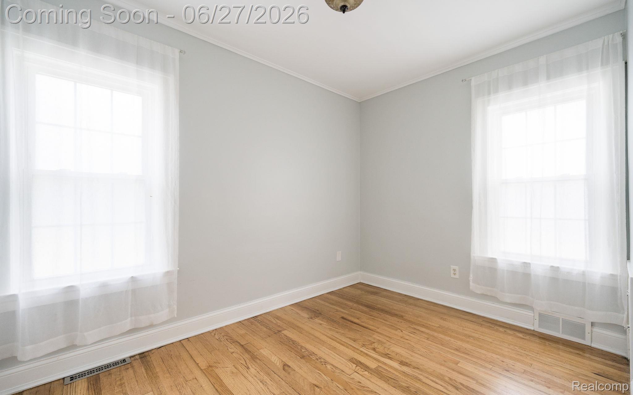39 Mohawk Road Pontiac, MI 48341 - Photo 18 of 32 Room featuring two windows, wood-finish flooring, light-colored walls, and white trim
