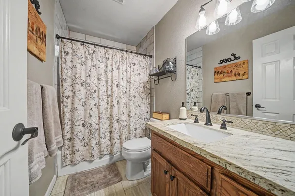 a bathroom with a granite countertop sink toilet and shower