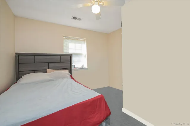 a bedroom with a bed and a potted plant