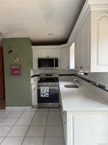 a kitchen with a refrigerator a stove top oven and a sink with wooden floor