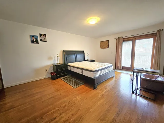 a spacious bedroom with a bed a couch and a large window