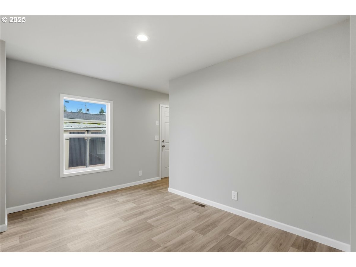 20815 Walnut Street Northeast Aurora, OR 97002 - Photo 4 of 32 a view of an empty room with wooden floor and a window