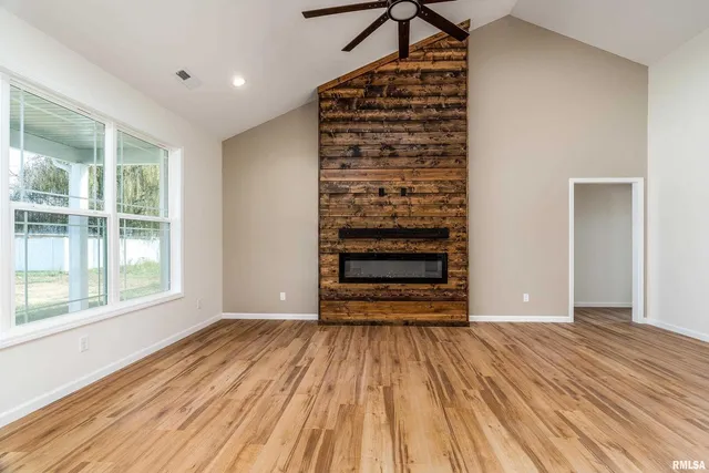 a view of empty room with wooden floor and window