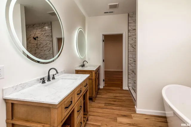 a en suite bathroom with a granite countertop sink and a mirror