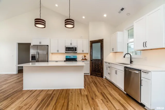 a kitchen with stainless steel appliances a stove refrigerator sink and microwave