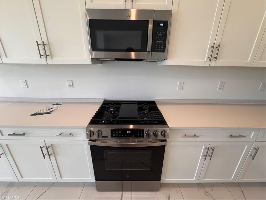 2864 Bloomfield Way Naples, FL 34112 - Photo 11 of 40 a stove top oven sitting inside of a kitchen