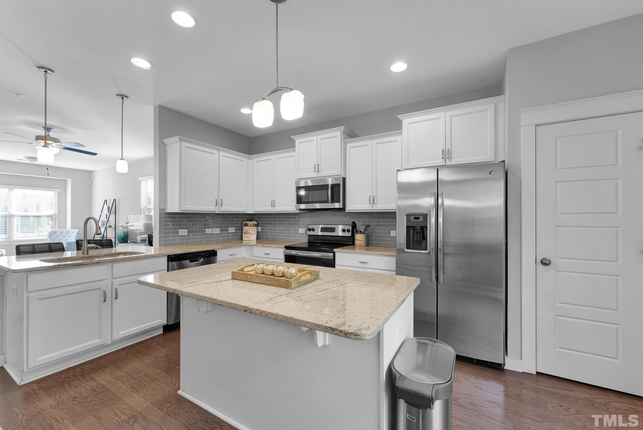 7810 Allscott Way Raleigh, NC 27612 - Photo 17 of 29 a kitchen with a refrigerator a sink and wooden floor