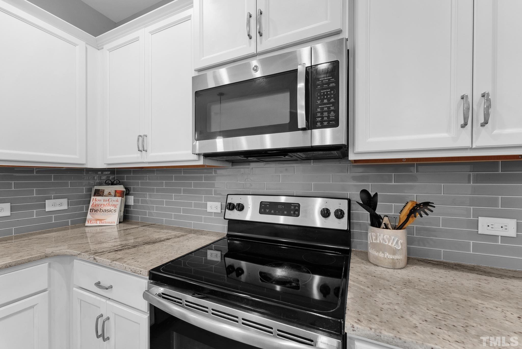 7810 Allscott Way Raleigh, NC 27612 - Photo 20 of 29 a kitchen with stainless steel appliances granite countertop white cabinets and a stove top oven