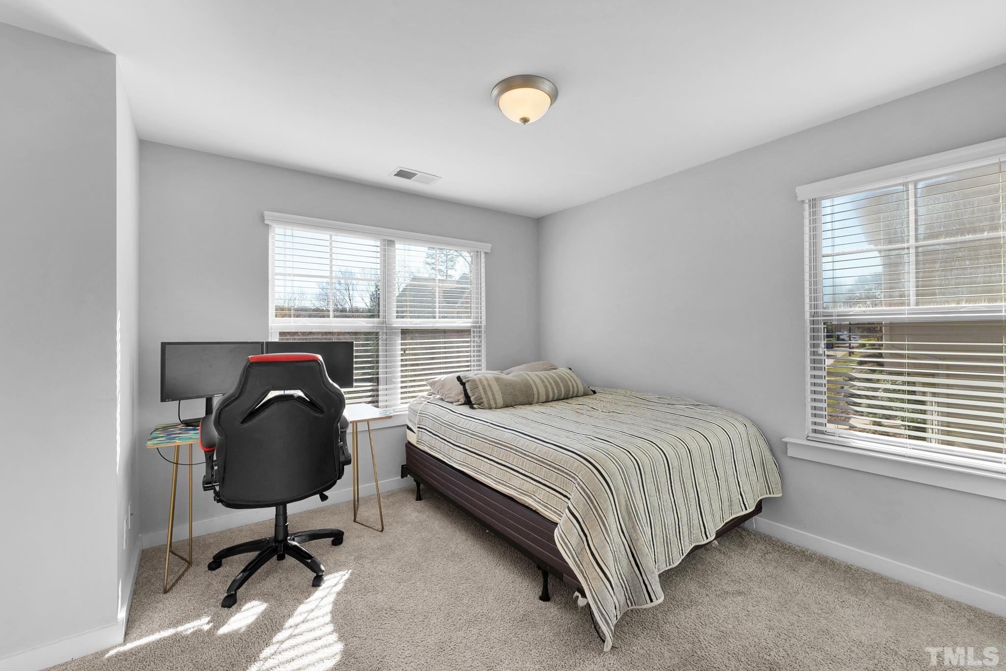 7810 Allscott Way Raleigh, NC 27612 - Photo 27 of 29 a bedroom with a bed chair and a window