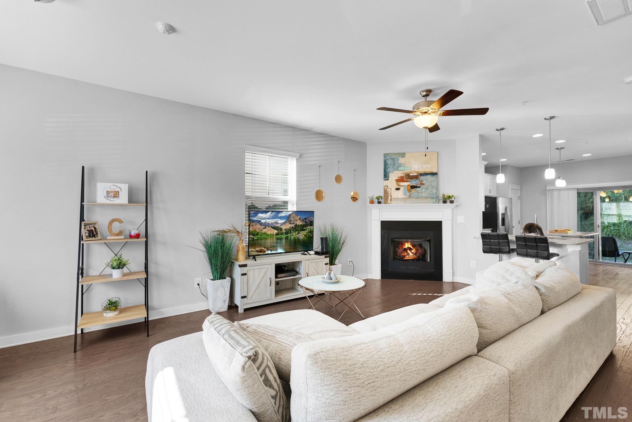 7810 Allscott Way Raleigh, NC 27612 - Photo 10 of 29 a living room with furniture a fireplace and a potted plant