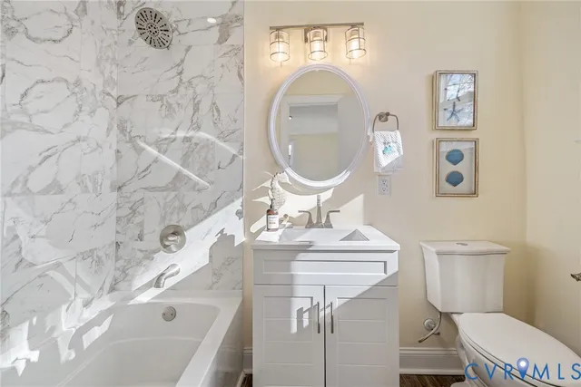 a bathroom with a sink mirror vanity and toilet