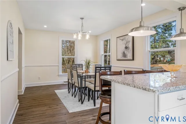 a view of a dining room and livingroom with furniture wooden floor a chandelier