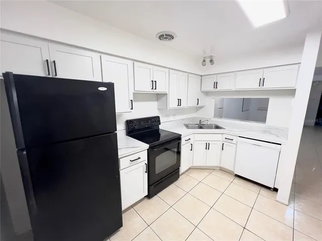 a kitchen with white cabinets and white appliances