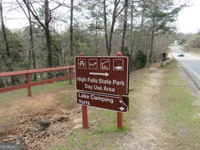 a view of a sign board with large trees