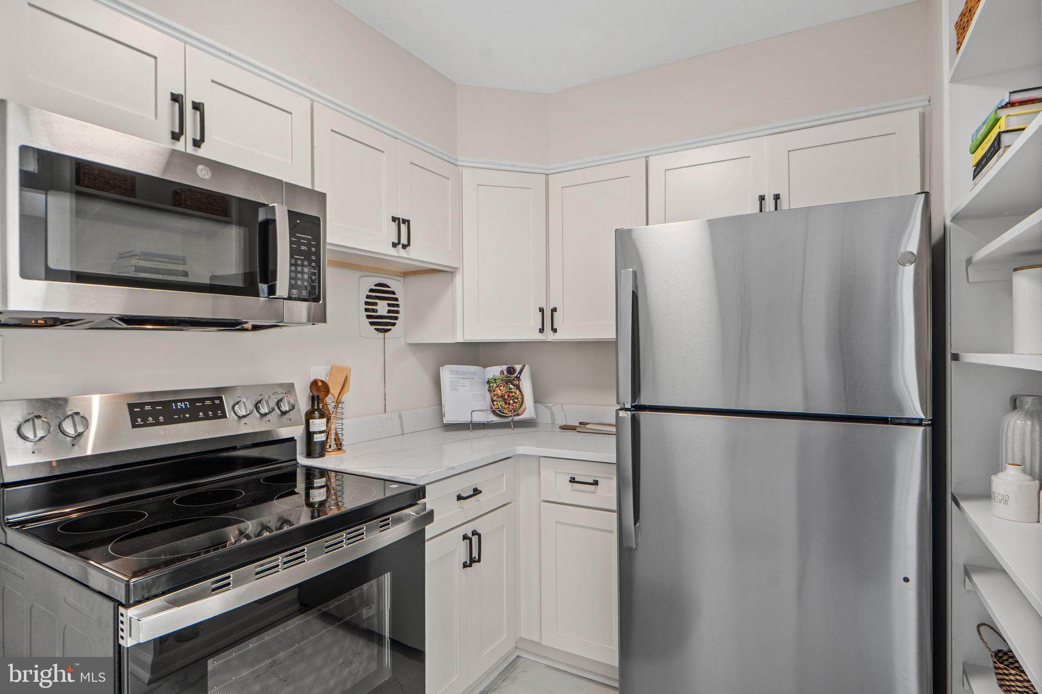 1513 Flora Lane Silver Spring, MD 20910 - Photo 13 of 49 a kitchen with stainless steel appliances a refrigerator stove and microwave