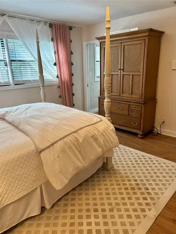 a bedroom with a bed dresser and a window