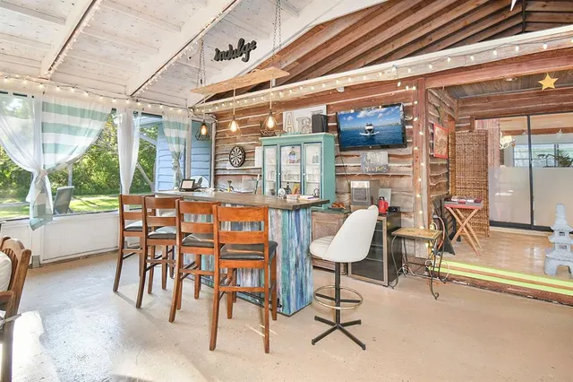 a dining room with furniture and large windows