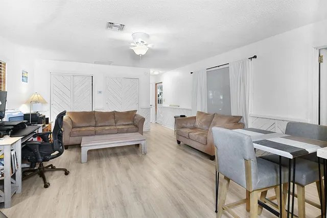 a living room with furniture and a wooden floor