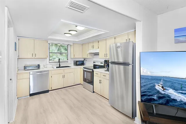 a kitchen with white cabinets and white appliances