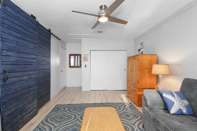 a bedroom with a bed and a lamp on the dresser