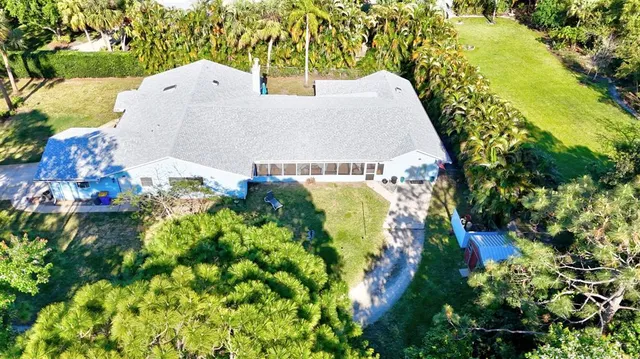 an aerial view of a house with a yard and garden in the back