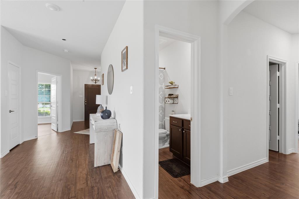 10101 Travis Road Little Elm, TX 75068 - Photo 11 of 26 a view of a hallway with wooden floor and a living room