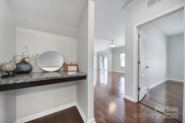 a bathroom with granite countertop a sink a toilet and view living room