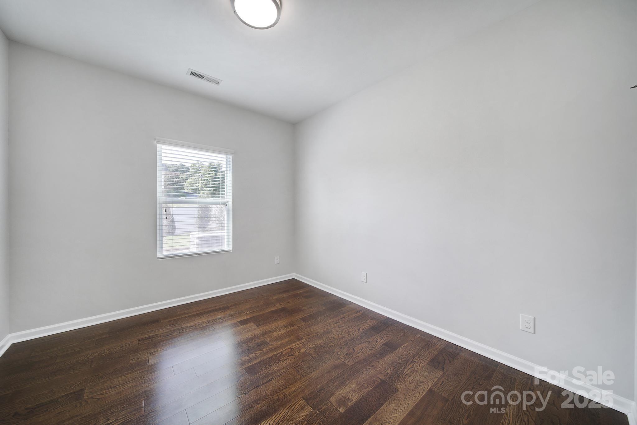 1541 Spring Blossom Trail Fort Mill, SC 29708 - Photo 21 of 43 an empty room with wooden floor and windows