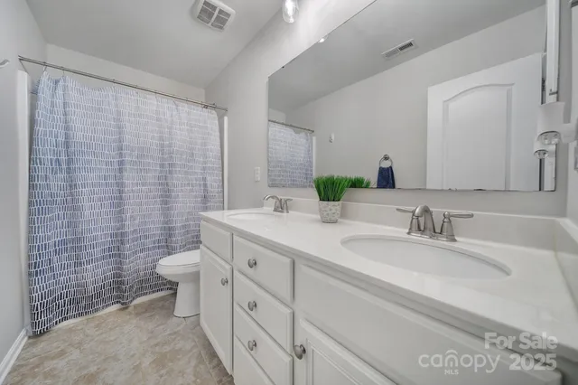 a bathroom with a granite countertop sink mirror vanity and toilet